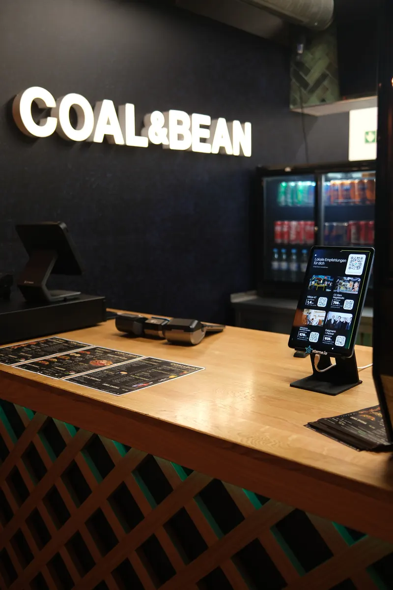 Café COAL & BEAN mit Tablet im Kassenbereich, darauf vier Empfehlungen aus der Nachbarschaft