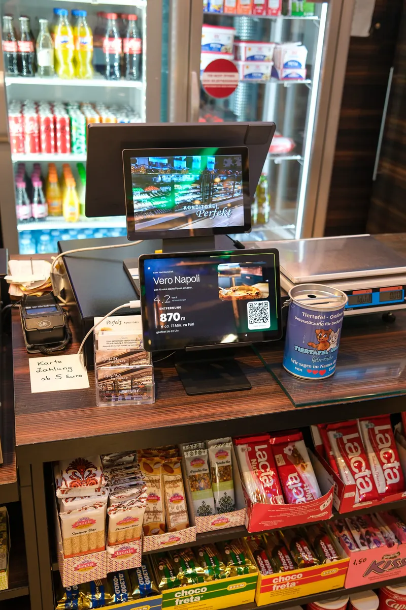 Tablet an der Kasse der Konditorei Perfekt, darauf die Pizzeria Vero Napoli, 870 Meter entfernt
